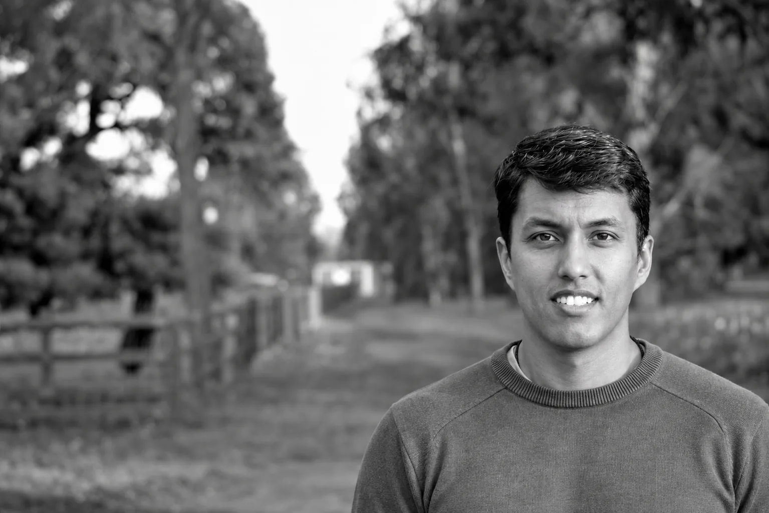 Joyanto Roy standing beside a tree-lined path.